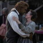 A woman and a man with textured skin embrace warmly.